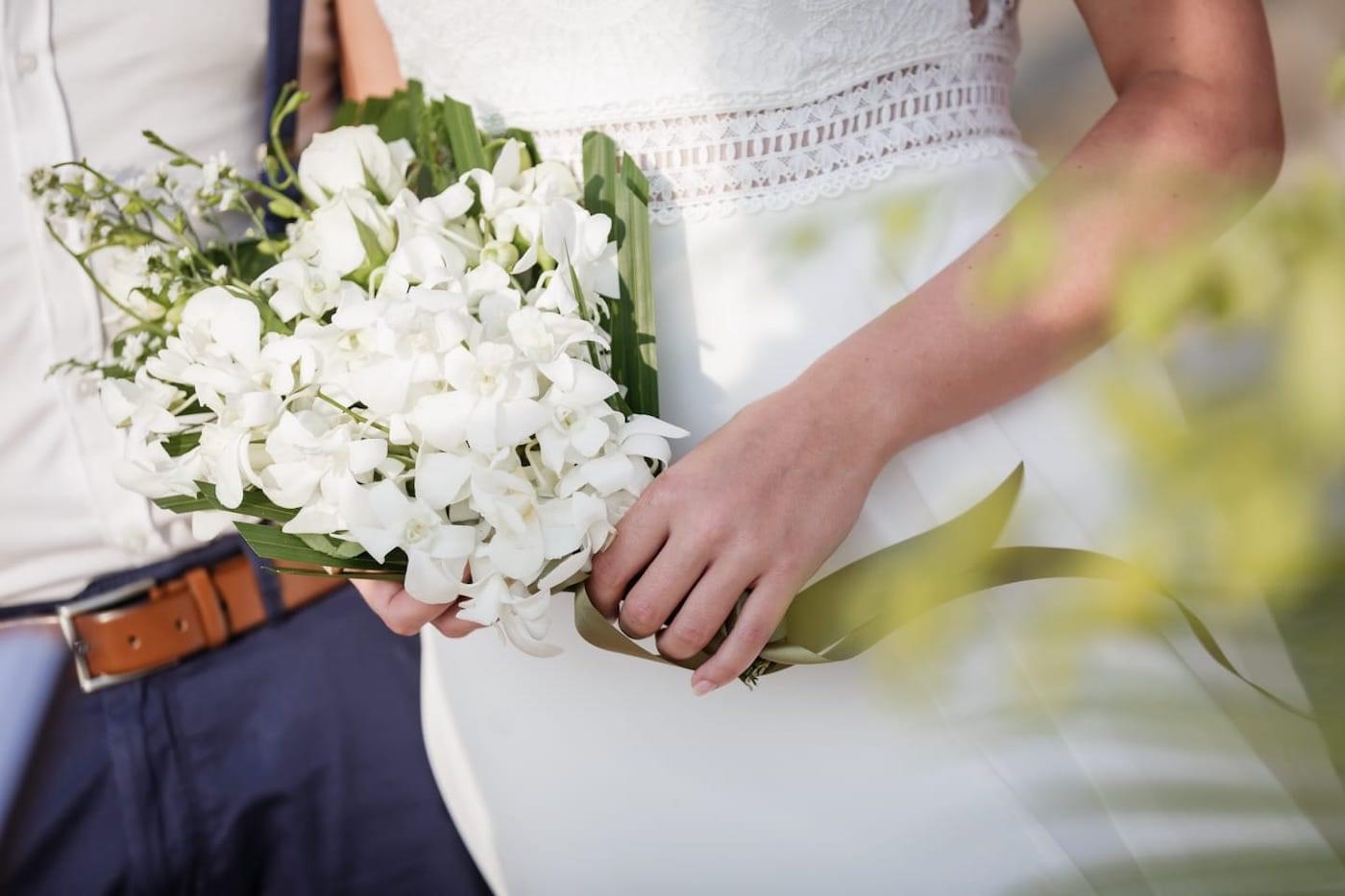 Bride and groom with flowers on beach